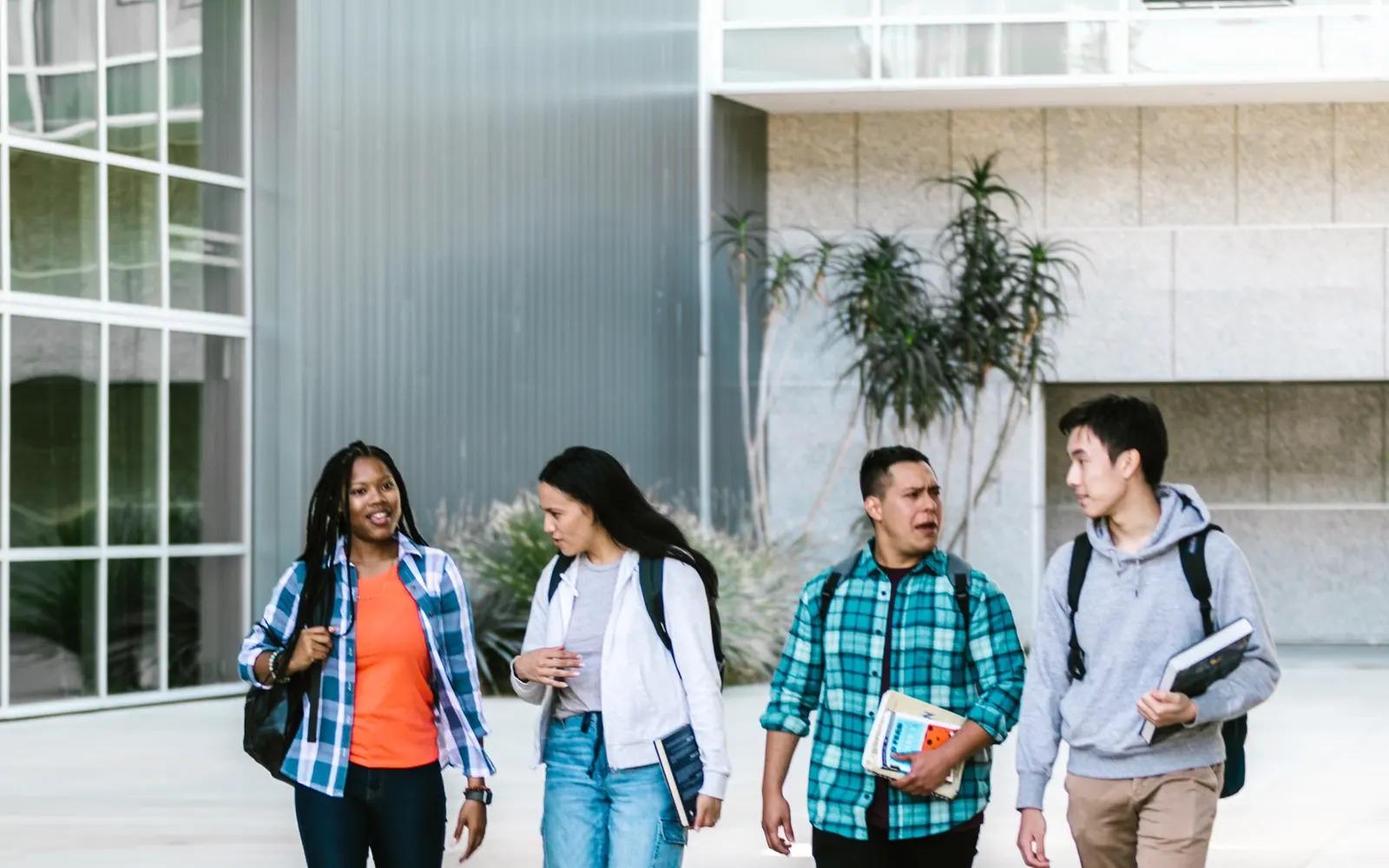 Grupo de estudiantes caminando juntos por un campus universitario
